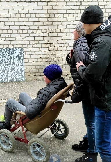 Жінка звертається до російських солдатів з хлопчиком з інвалідністю