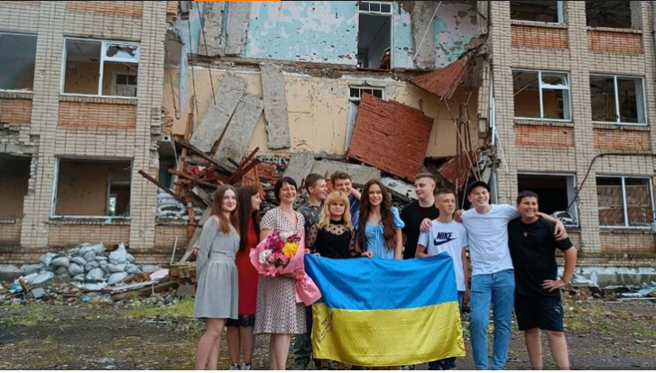 Старшокласники Любимівської школи Бериславського району на фоні зруйнованої окупантами будівлі школи