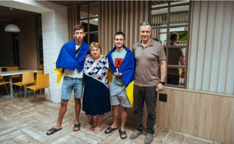 Сергій (ліворуч) та Денис Бережний (у центрі, праворуч) у штаб-квартирі Save Ukraine у ​​Києві з Миколою Кулебою (праворуч), генеральним директором організації 