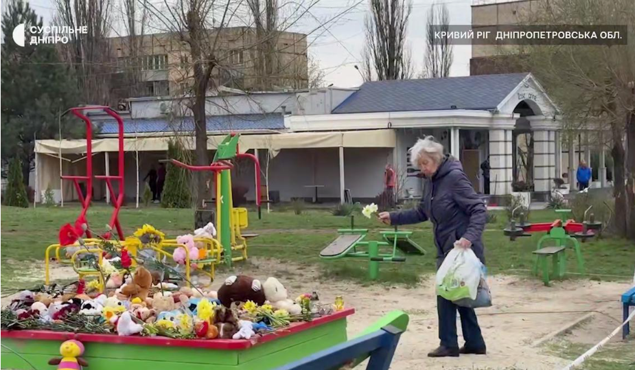 Люди несуть дитячі іграшки та квіти до місця загибелі дітей.